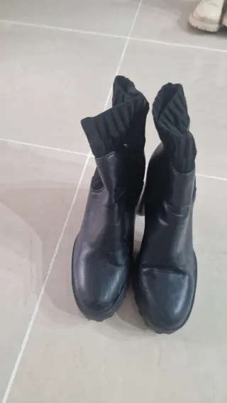 Botas altas negras con hebillas.