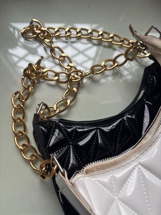 Bolso blanco y negro con cadena dorada