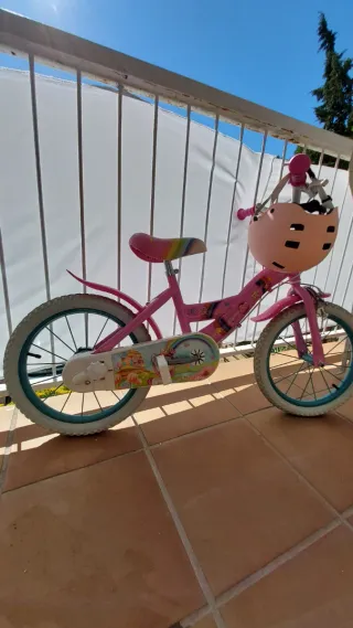 Bicicleta infantil rosa con ruedas turquesa