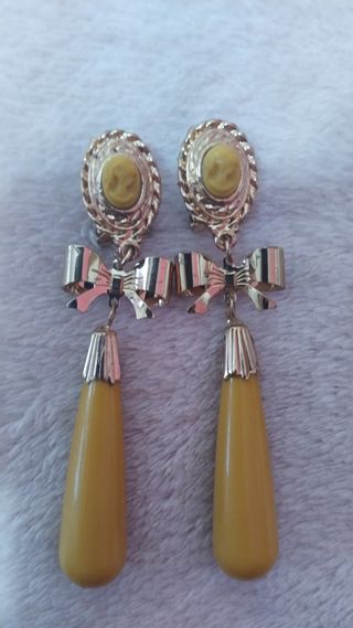 Flor y pendientes dorados mostaza