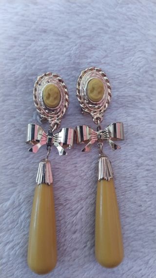 Flor y pendientes dorados mostaza