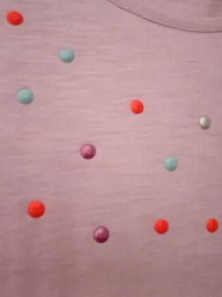 Camiseta rosa con tachuelas de colores