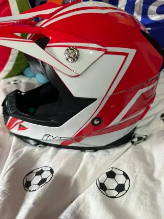 Casco de moto rojo y blanco con gafas