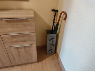 Paragüero metálico gris con diseño de paraguas