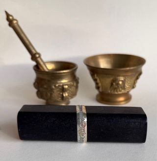 Mortero antiguo bronce con mano