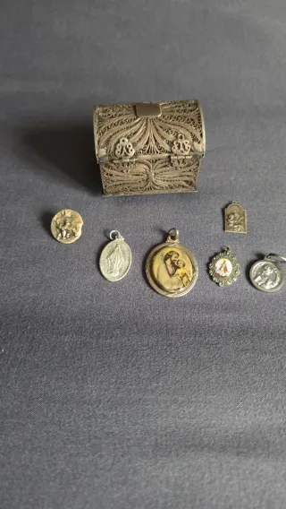 Baúl de plata y colgantes religiosos