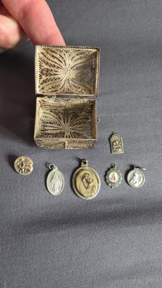 Baúl de plata y colgantes religiosos
