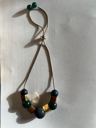 Pulsera dorada con cuentas azules y verdes