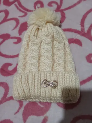 Gorro de lana beige con pompón y detalle
