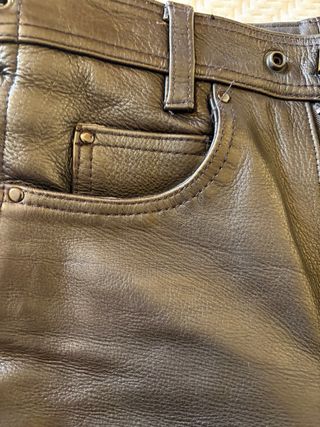 Pantalones de cuero negro con cuerdas.