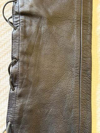 Pantalones de cuero negro con cuerdas.