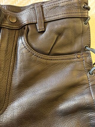 Pantalones de cuero negro con cuerdas.