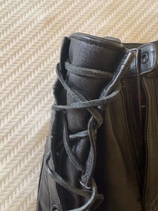 Pantalones de cuero negro con cuerdas.