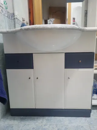 Mueble de baño con lavabo y espejo, con grifo.