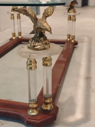 Antigua mesa de cristal con águilas.