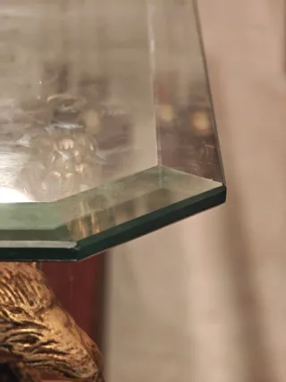 Antigua mesa de cristal con águilas.