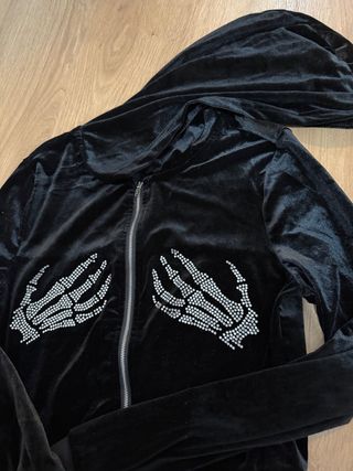 Chaqueta negra con manos de esqueleto brillantes