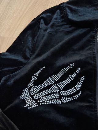 Chaqueta negra con manos de esqueleto brillantes