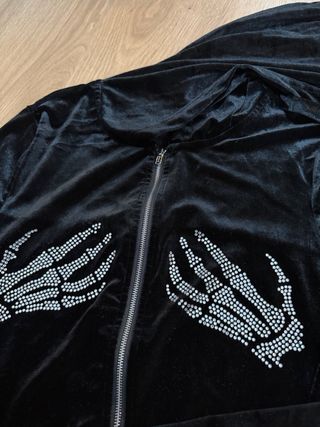 Chaqueta negra con manos de esqueleto brillantes