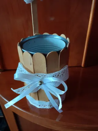 Lata decorada con palitos y lazo blanco