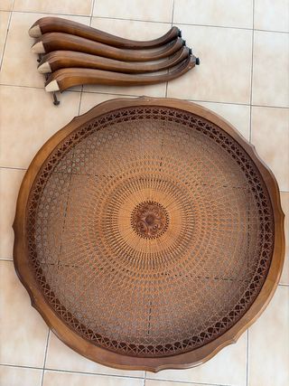 Mesa redonda de mimbre con detalle tallado madera.