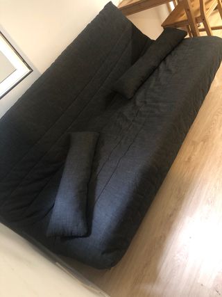 Sofá cama gris oscuro con almohada
