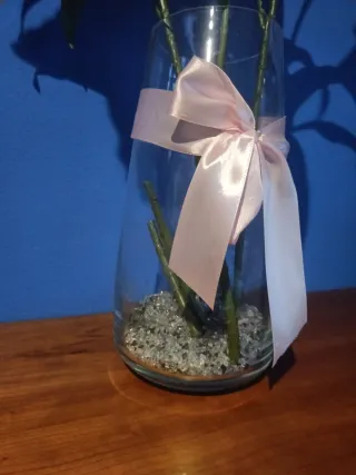 Florero de cristal con flores y piedras