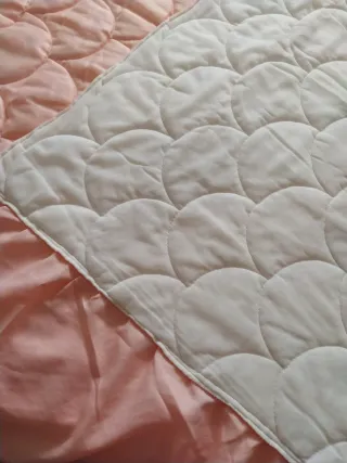 Colcha rosa con diseño de conchas