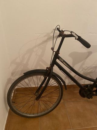 Bicicleta clásica negra con óxido.
