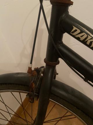 Bicicleta clásica negra con óxido.