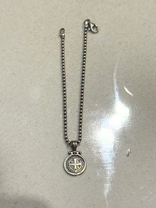 Pulsera plateada con dije religioso