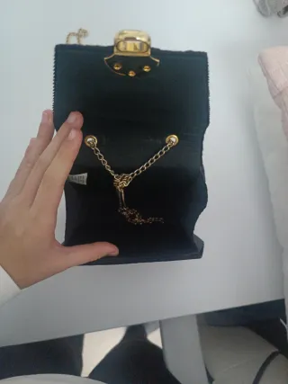 Bolso de terciopelo negro con cadena dorada