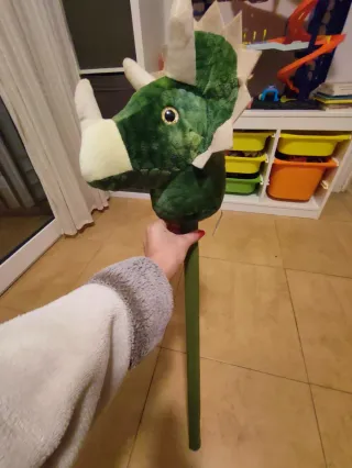Dinosaurio de peluche con palo