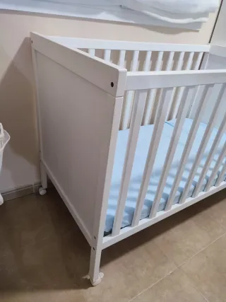 Cuna blanca con colchón azul