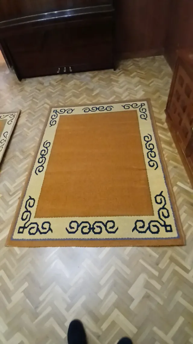 Alfombra naranja y beige con dibujos.
