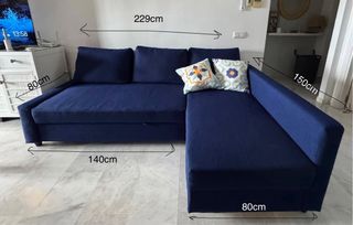 Sofá cama azul con cojines.