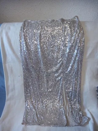 Falda larga dorada de lentejuelas con abertura.