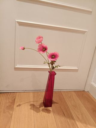 Flor artificial rosa con jarrón de cristal