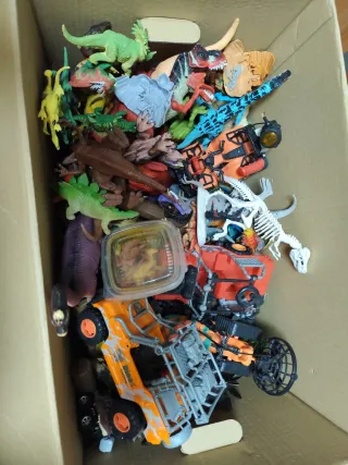 Caja de dinosaurios y vehículos de juguete