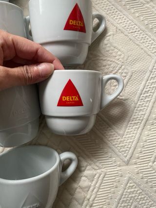 Taza de porcelana blanca Delta con plato a juego.