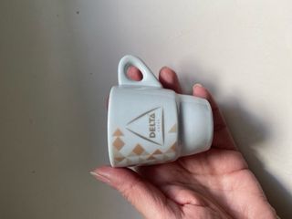 Taza de porcelana blanca Delta con plato a juego.