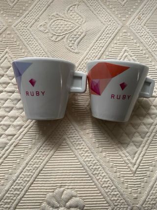 Taza de porcelana blanca Delta con plato a juego.