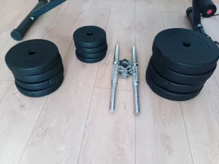 Banco de gimnasio con pesas y mancuernas