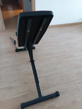 Banco de gimnasio con pesas y mancuernas