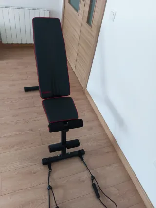 Banco de gimnasio con pesas y mancuernas