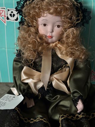 Muñeca de porcelana con vestido verde