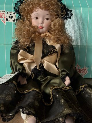 Muñeca de porcelana con vestido verde