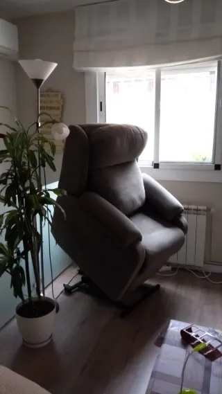 Sillón reclinable eléctrico color gris.