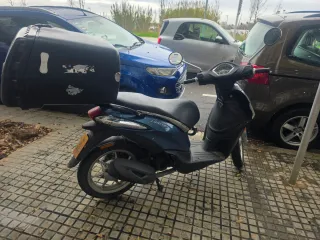 Ciclomotor azul con baúl grande para repartos