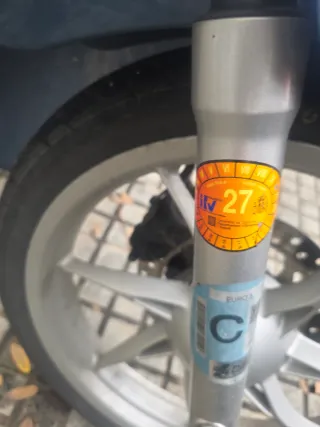 Ciclomotor azul con baúl grande para repartos